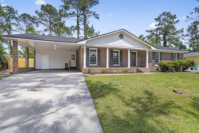 view of front of property featuring board and batten siding, a front yard, brick siding, fence, and concrete driveway