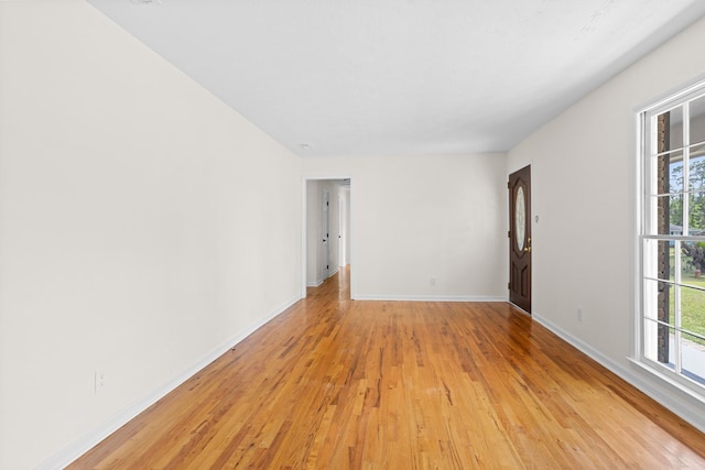 spare room with baseboards and light wood-style flooring