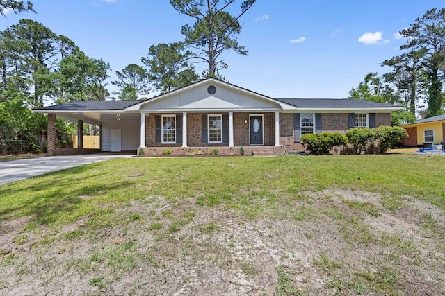 view of front facade featuring brick siding, driveway, a front yard, and a carport