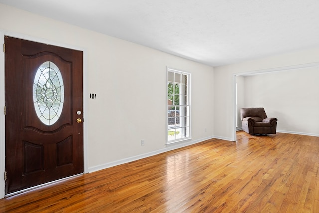 entryway with baseboards, plenty of natural light, and light wood-type flooring