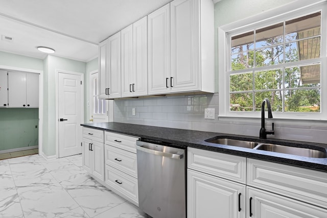 kitchen featuring stainless steel dishwasher, a sink, decorative backsplash, and white cabinetry