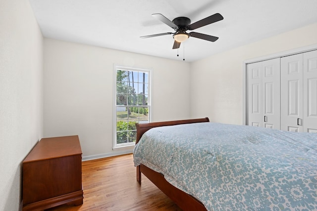 bedroom with baseboards, ceiling fan, a closet, and wood finished floors