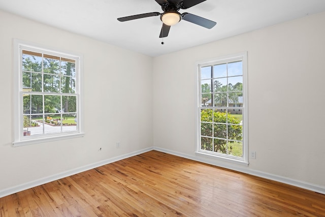 spare room featuring baseboards, ceiling fan, and light wood-style flooring