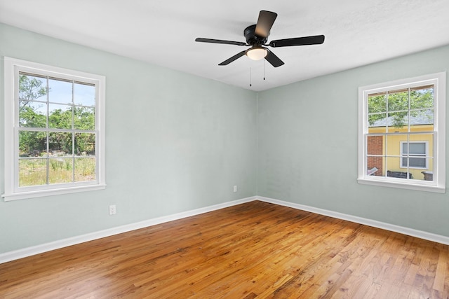 empty room with baseboards, ceiling fan, and wood finished floors