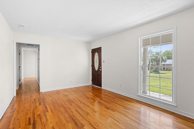 foyer entrance with light wood-style floors, baseboards, and visible vents