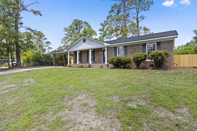 view of front of property featuring covered porch, a front yard, brick siding, fence, and concrete driveway