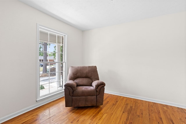 sitting room featuring baseboards and light wood finished floors