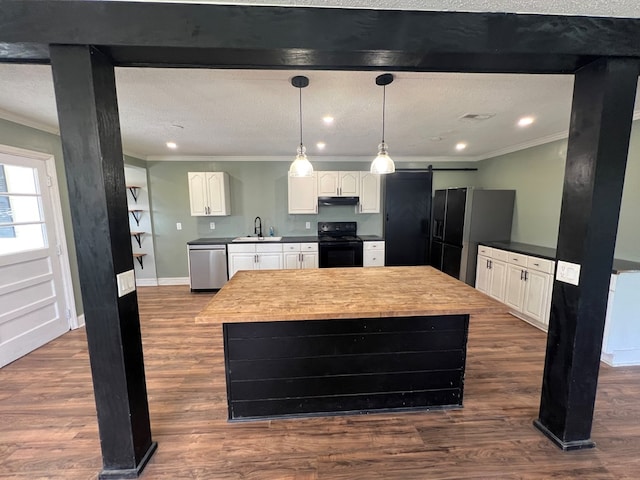 kitchen with crown molding, black appliances, a barn door, under cabinet range hood, and a sink