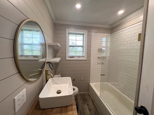 bathroom with toilet, a wealth of natural light, wood finished floors, and a textured ceiling