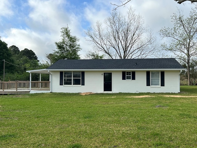 ranch-style house with roof with shingles, a front yard, and concrete block siding