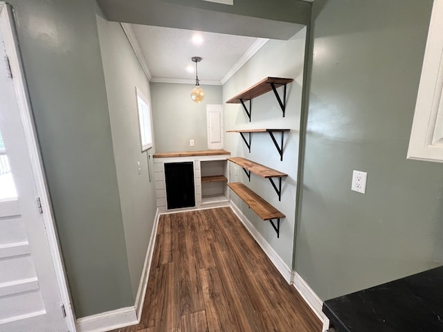 interior space featuring dark wood-style floors, baseboards, and ornamental molding