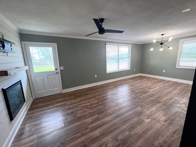 unfurnished living room with dark wood-style floors, a large fireplace, crown molding, and a textured ceiling