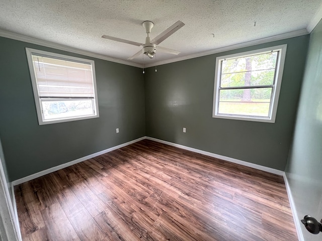 unfurnished room featuring a wealth of natural light, crown molding, a ceiling fan, and wood finished floors