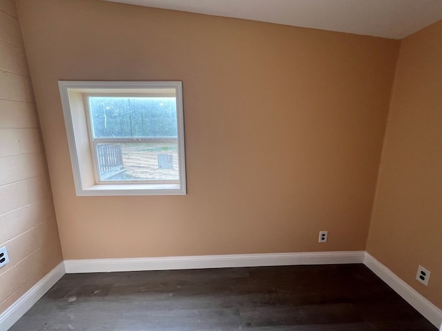 empty room with dark wood-type flooring and baseboards