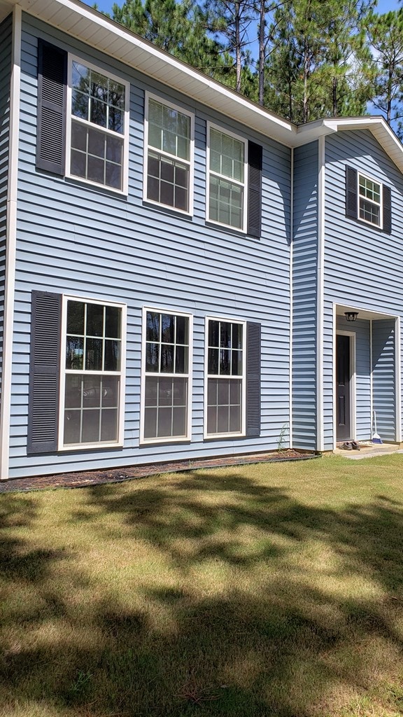 view of side of home with a lawn