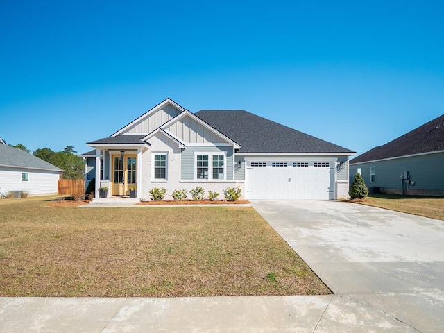 view of front of home featuring driveway, a garage, roof with shingles, a front lawn, and board and batten siding