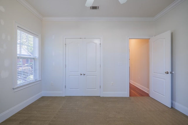 unfurnished bedroom featuring ceiling fan, a closet, carpet, and ornamental molding