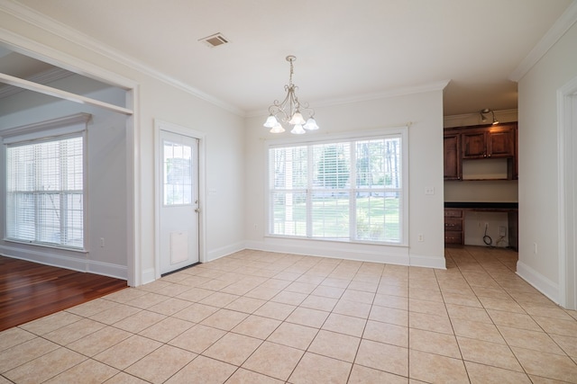 unfurnished dining area with light tile patterned flooring, ornamental molding, and a chandelier