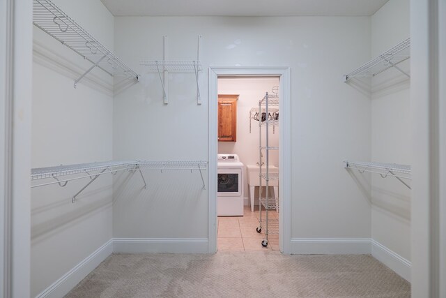 walk in closet with washer / dryer, light colored carpet, and sink