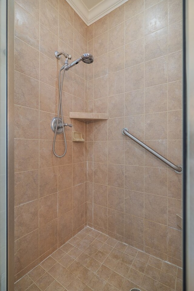 bathroom featuring a tile shower and ornamental molding