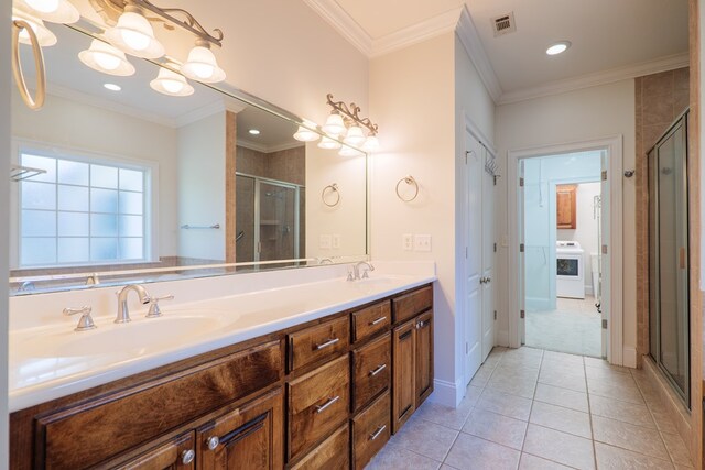 bathroom featuring tile patterned floors, washer / clothes dryer, crown molding, an enclosed shower, and vanity