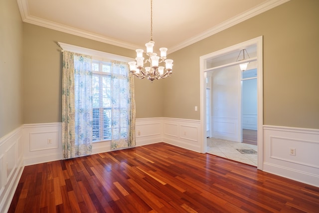 unfurnished room with wood-type flooring, ornamental molding, and a chandelier