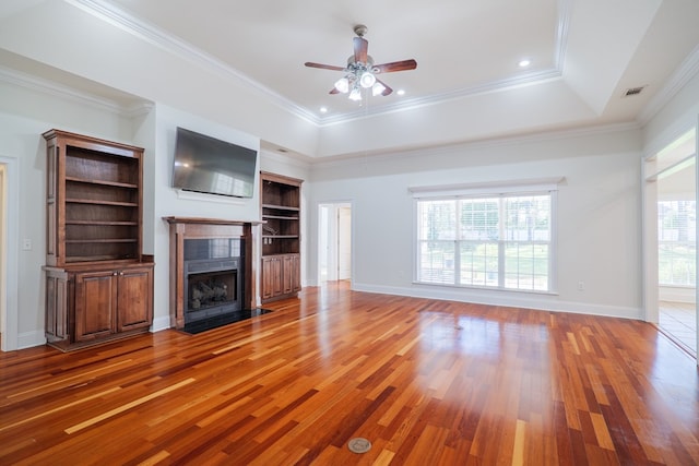 unfurnished living room featuring crown molding, a healthy amount of sunlight, and hardwood / wood-style flooring