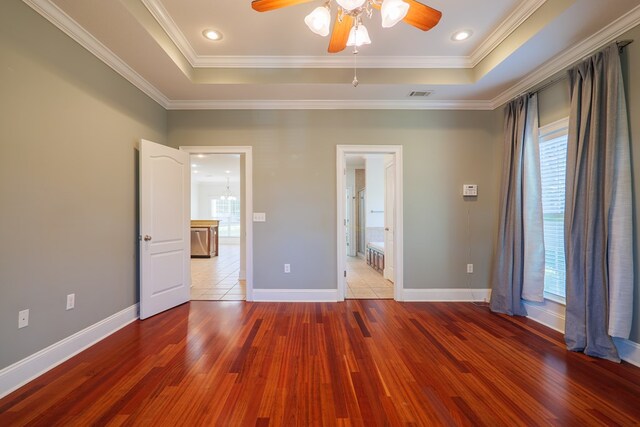 unfurnished bedroom featuring hardwood / wood-style floors, ornamental molding, and ensuite bath