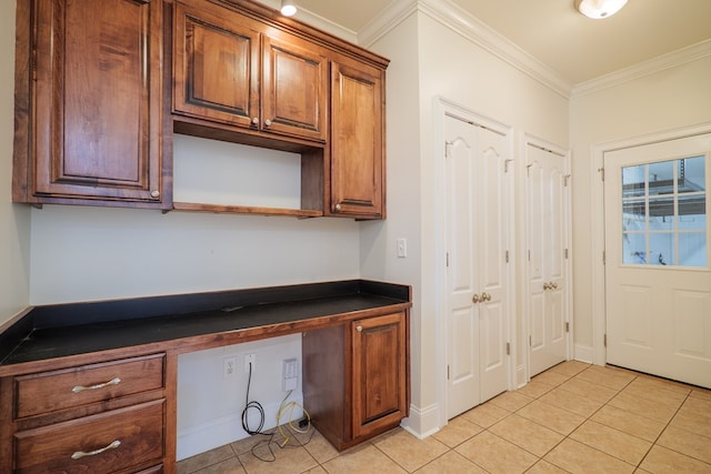 kitchen with light tile patterned flooring, built in desk, and ornamental molding