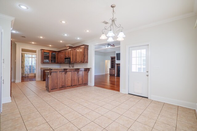 kitchen with kitchen peninsula, a chandelier, and ornamental molding