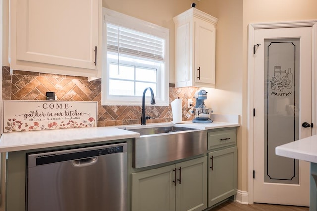 kitchen with dishwasher, white cabinets, and sink