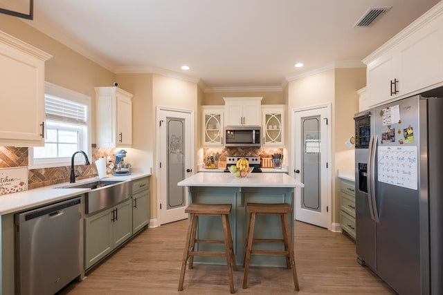 kitchen with decorative backsplash, white cabinets, a center island, and stainless steel appliances