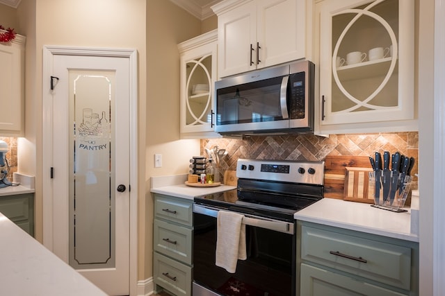 kitchen featuring white cabinets, backsplash, crown molding, and stainless steel appliances