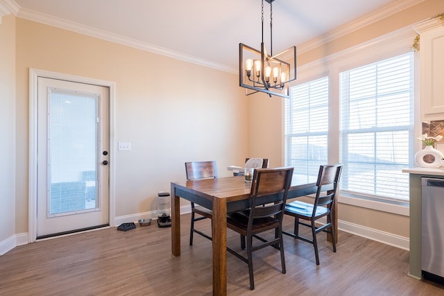 dining room featuring ornamental molding, light hardwood / wood-style floors, and a notable chandelier