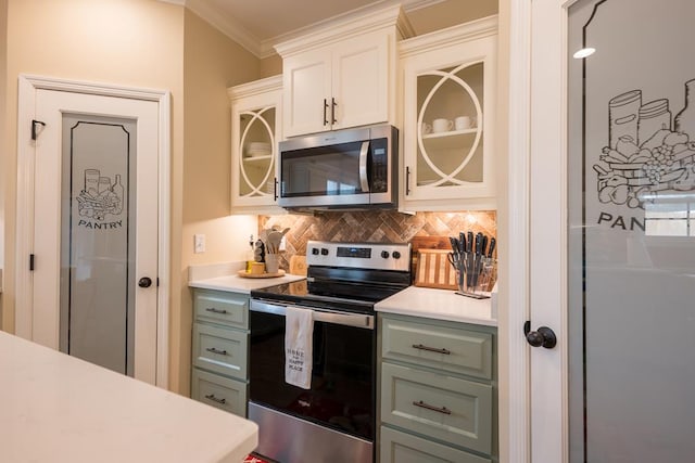 kitchen featuring backsplash, crown molding, appliances with stainless steel finishes, green cabinetry, and white cabinets