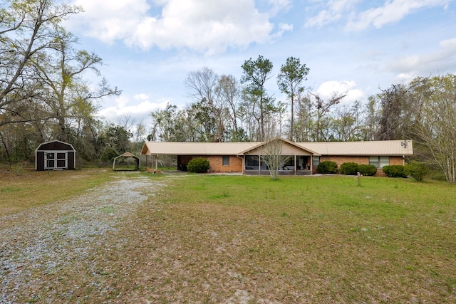 ranch-style home featuring a front lawn and a shed