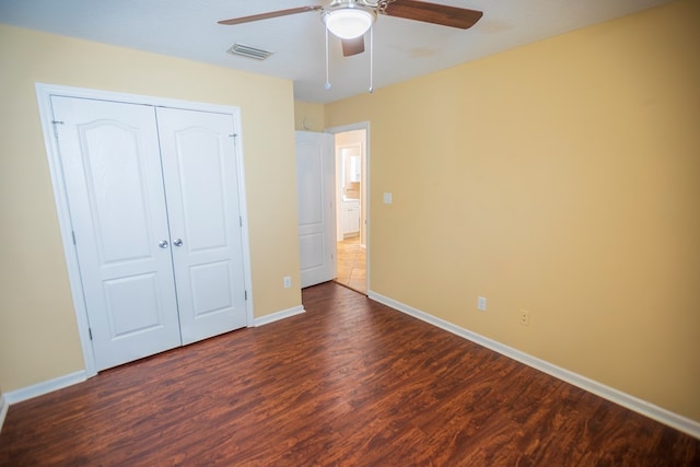 unfurnished bedroom featuring dark wood-type flooring, ceiling fan, and a closet