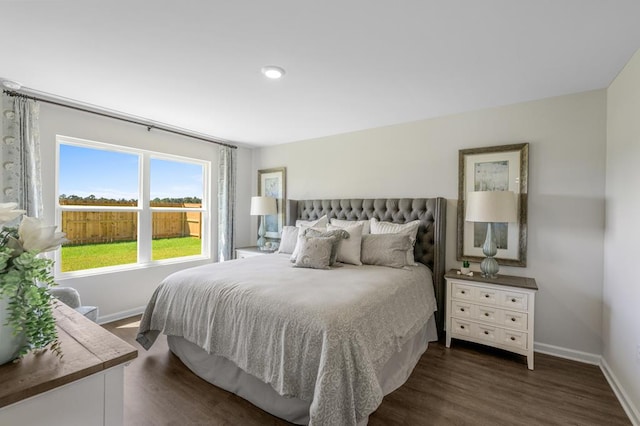 bedroom with dark wood-type flooring and baseboards