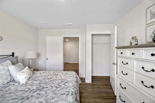 bedroom with a closet, dark wood finished floors, and baseboards