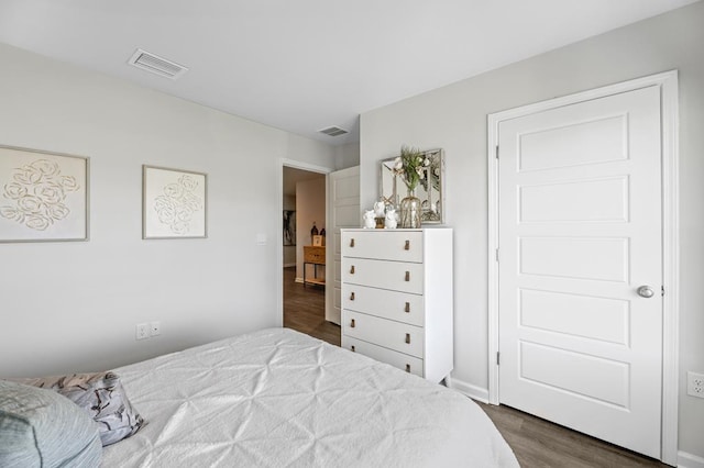 bedroom featuring visible vents and dark wood finished floors