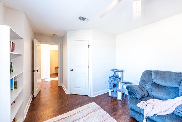 living area with ceiling fan and dark hardwood / wood-style flooring