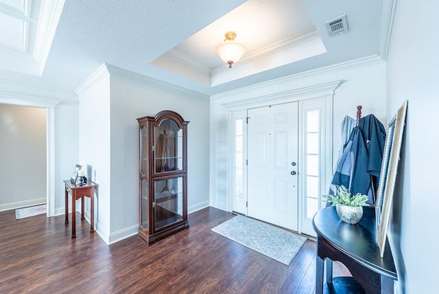 entrance foyer featuring a raised ceiling, crown molding, and dark hardwood / wood-style floors