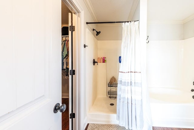 bathroom featuring ornamental molding, a textured ceiling, and walk in shower