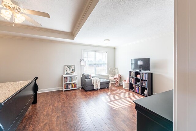 interior space featuring crown molding, ceiling fan, dark wood-type flooring, and a textured ceiling