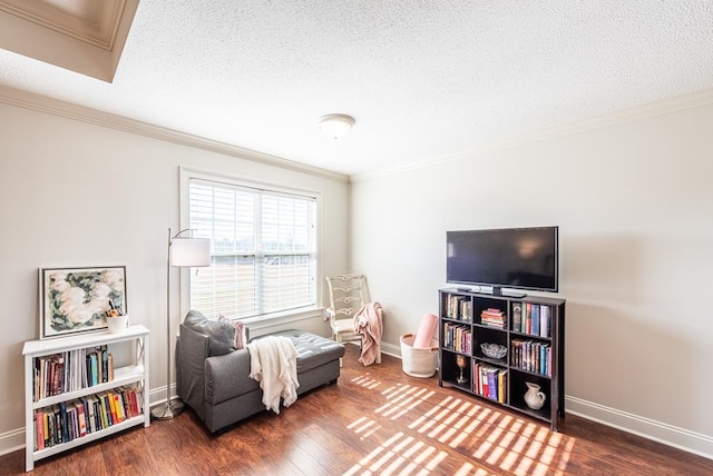 sitting room with a textured ceiling, dark hardwood / wood-style floors, and ornamental molding