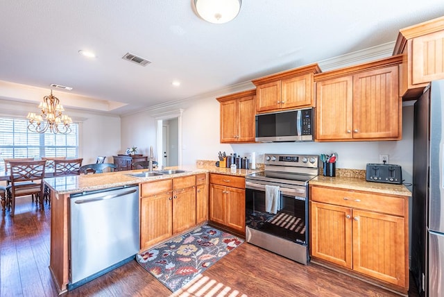 kitchen with kitchen peninsula, stainless steel appliances, dark wood-type flooring, sink, and an inviting chandelier