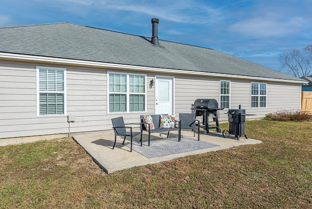 rear view of property featuring a lawn and a patio area