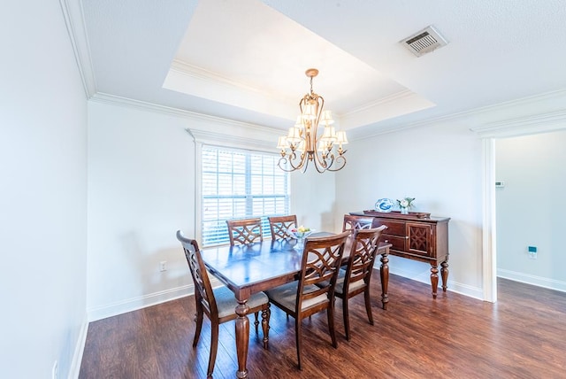 dining area with a notable chandelier, crown molding, dark wood-type flooring, and a tray ceiling