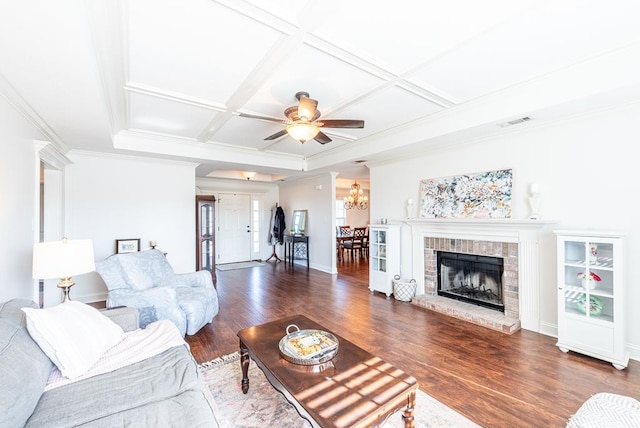 living room featuring dark hardwood / wood-style flooring, a brick fireplace, ornamental molding, coffered ceiling, and ceiling fan