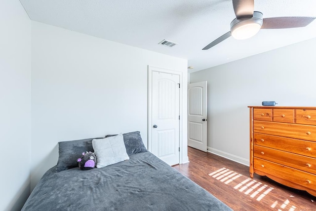 bedroom with dark hardwood / wood-style flooring and ceiling fan